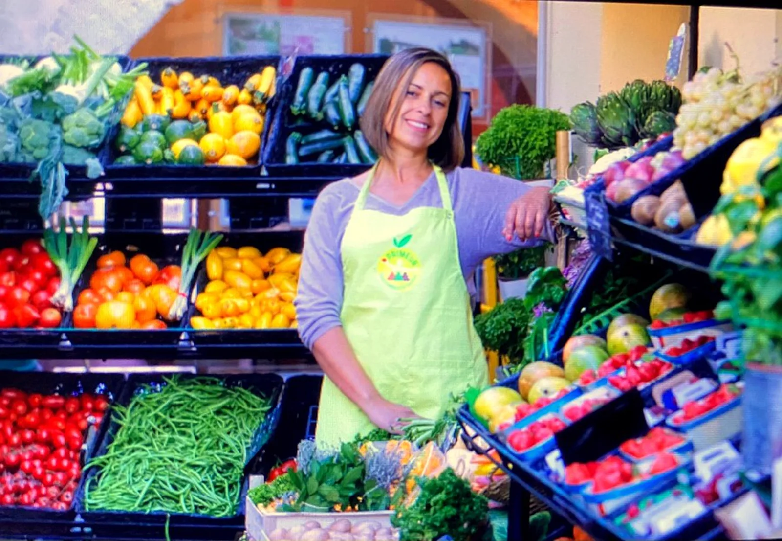 Samira Lemaire dans son commerce d’Uzès, entourée des étals de fruits et légumes.